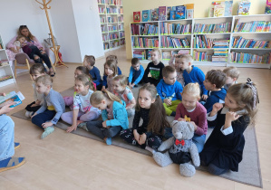 dzieci siedzą na dywanie