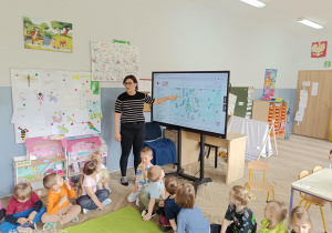 dzieci siedzą przed monitorem multimedilanym