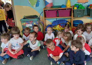 dzieci siedzą na podłodze