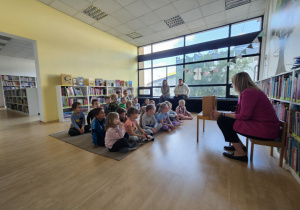 dzieci siedzą na dywanie