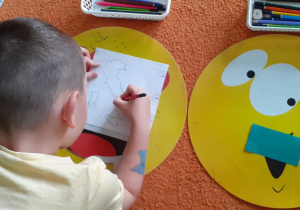 chłopiec zaznacza stolicę Włoch na małej mapce