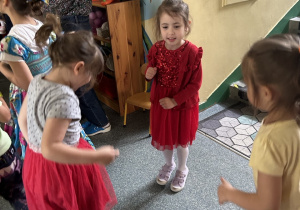 trzy dziewczynki tańczą w kole