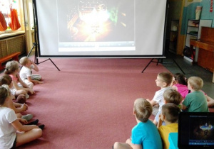 dzieci oglądają bajkę wyświetlaną na projektorze
