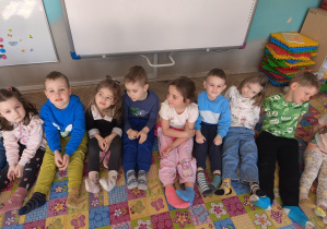Dzieci siedzą z różnymi skarpetkami na nogach