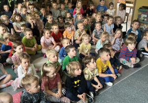 dzieci siedzą na dywanie