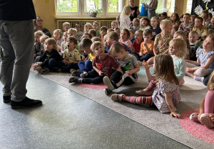 dzieci siedzą na dywanie