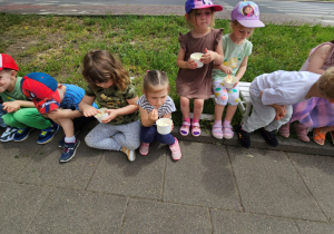Dzieci siedzą i jedza lody