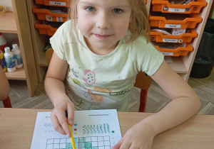 dziewczynka wykonuje kartę pracy