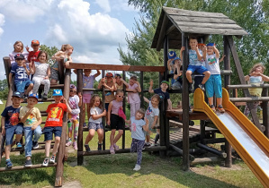 Grupa dzieci na drewnianych drabinkach ze zjeżdżalnią