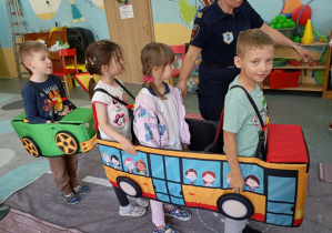 Czworo dzieci w miękkiej atrapie autobusu i autka