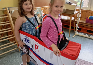 dwie dziewczynki w atrapie ambulansu