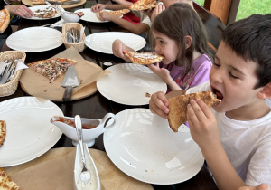dzieci jedzą pizzę