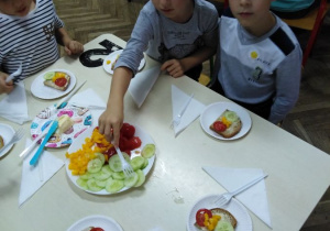 dzieci nakładają warzywa na kanapki