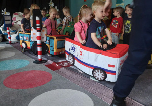 dzieci w miękkiej atrapie autobusu i autka