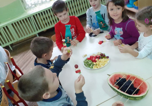 dzieci nakłuwają owoce