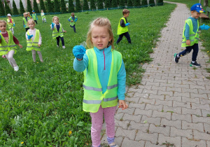 dziewczyna stoi na chodniku i trzyma w ręku kawałek szkła