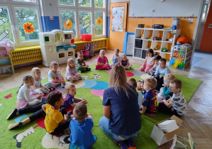 Dzieci siedzą w kole z Panią