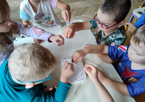 Dzieci przelewają wodę pipetami