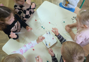 Dzieci z probówkami i pipetami przy stole