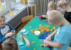 dzieci wycinają różne materiały i trzymają warzywa
