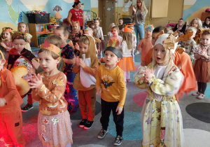 dzieci stoją na dywanie i klaszczą w ręce