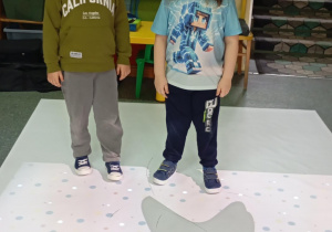 dwóch chłopców stoi na macie interaktywnej