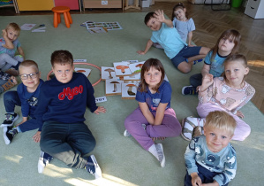 dzieci siedzą na dywanie