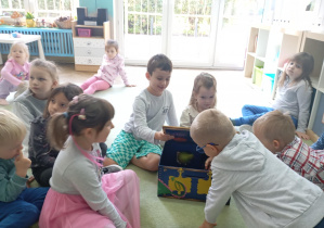 dzieci wyciągają przedmioty z pudełka