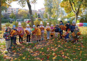 Dzieci z bukietami liści w ogrodzie