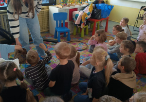 pani podaje papierową torebkę dziecku, z której wyciąga obrazek