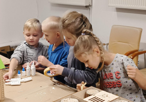 dzieci pracują technicznie z taśmami przy domku dla pszczół