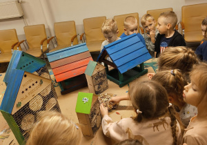grupa dzieci z pomalowanymi domkami i karmnikami