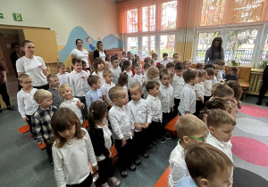 dzieci stoją na baczność podczas hymnu