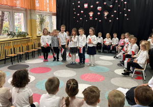 dzieci ubrane w galowe stroje recytują wiersze