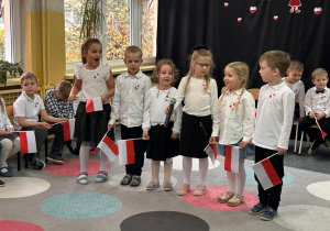 dzieci ubrane w galowe stroje recytują wiersze