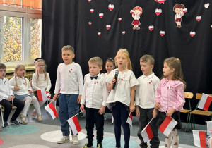 dzieci ubrane w galowe stroje recytują wiersze