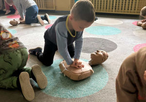 chłopiec ćwiczy resuscytacje na fantomie