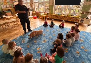 funkcjonariusz rozmawia z dziećmi na temat bezpieczeństwa w kontaktach ze zwierzętami