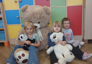 dzieci pozują do zdjęcia z pluszowymi misiami