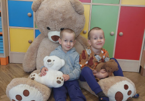 dzieci pozują do zdjęcia z pluszowymi misiami