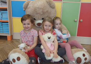 dzieci pozują do zdjęcia z pluszowymi misiami