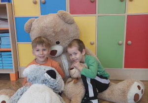 dzieci pozują do zdjęcia z pluszowymi misiami