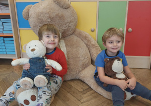 dzieci pozują do zdjęcia z pluszowymi misiami