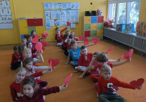 dzieci w dwóch rzędach wystawiają serca