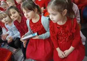 Dzieci siedzące w czerwonych ubraniach