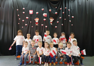 Dzieci w galowych strojach na tle dekoracji