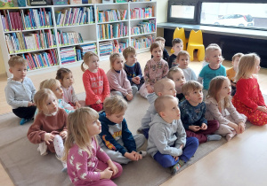 dzieci siedzą na dywanie