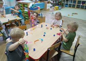 dzieci wykonują łańcuch na choinkę