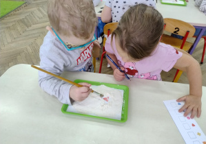 dwoje dzieci wyszukuje w mące elementów