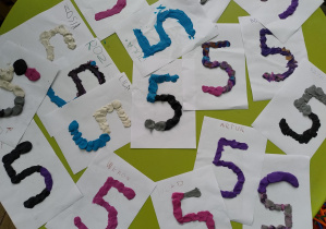 prace dzieci wyklejone plasteliną przedstawiające cyfrę 5